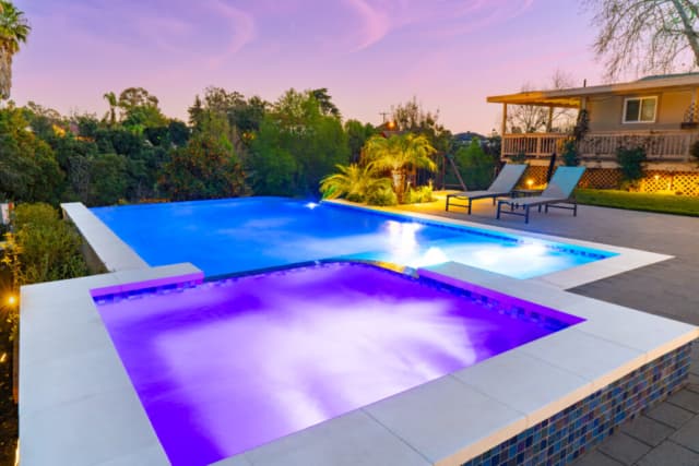 Modern infinity-edge pool lit at twilight